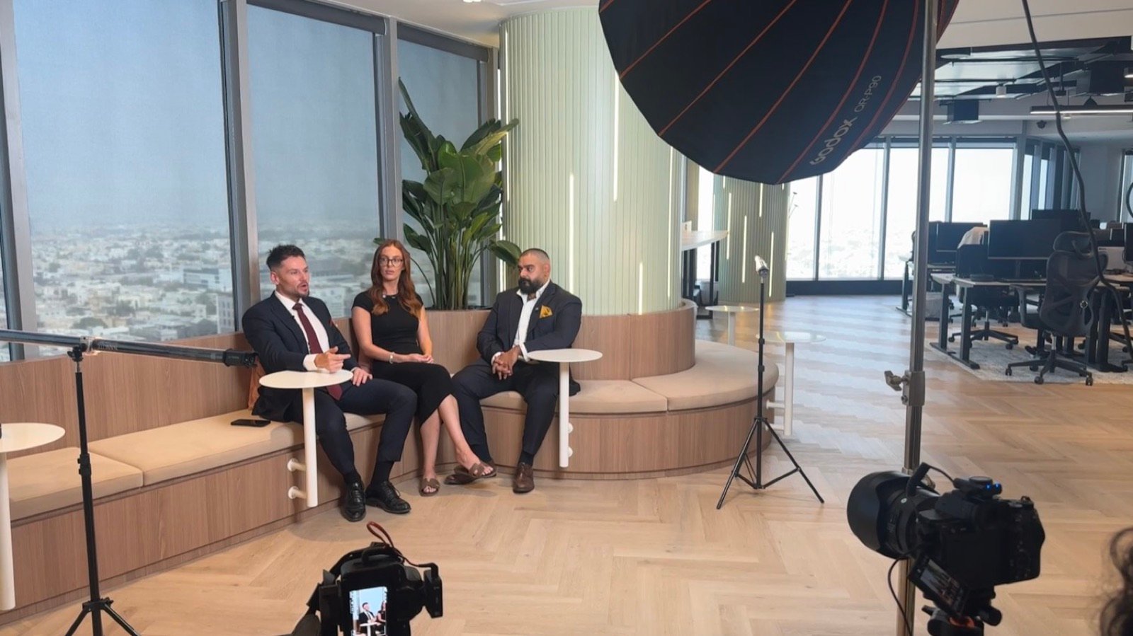 Three guests recording a multi-camera conversation in a Dubai office, with CEMA's cameras and softbox lighting